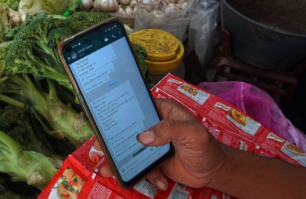 Penjual mendata pesanan dari pelanggan untuk belanja kebutuhan sehari-hari secara daring di pasar tradisional Kota Kediri, Jawa Timur.